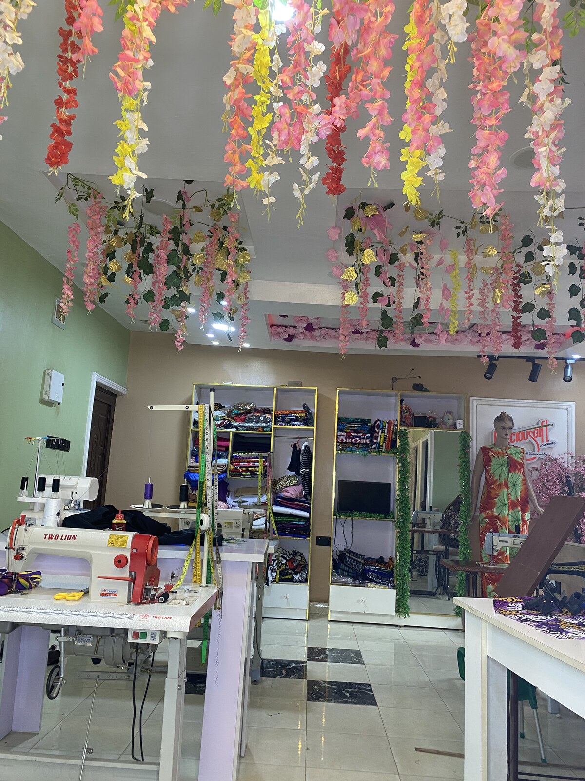 Tailoring floor with sewing machines and floral garlands